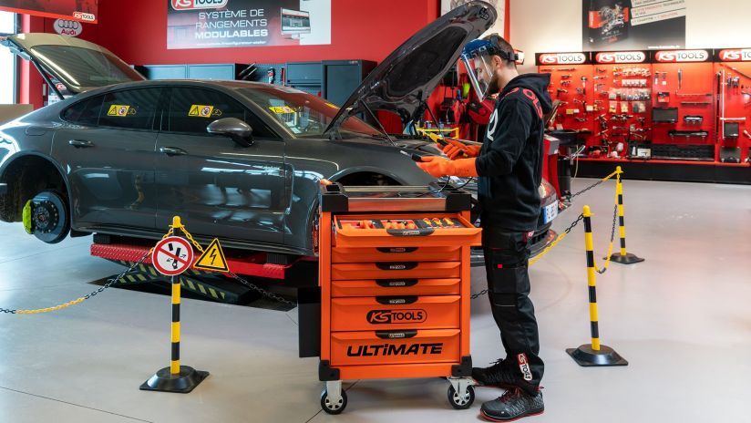Un artisan automobile utilise de l'outillage pour voiture électrique